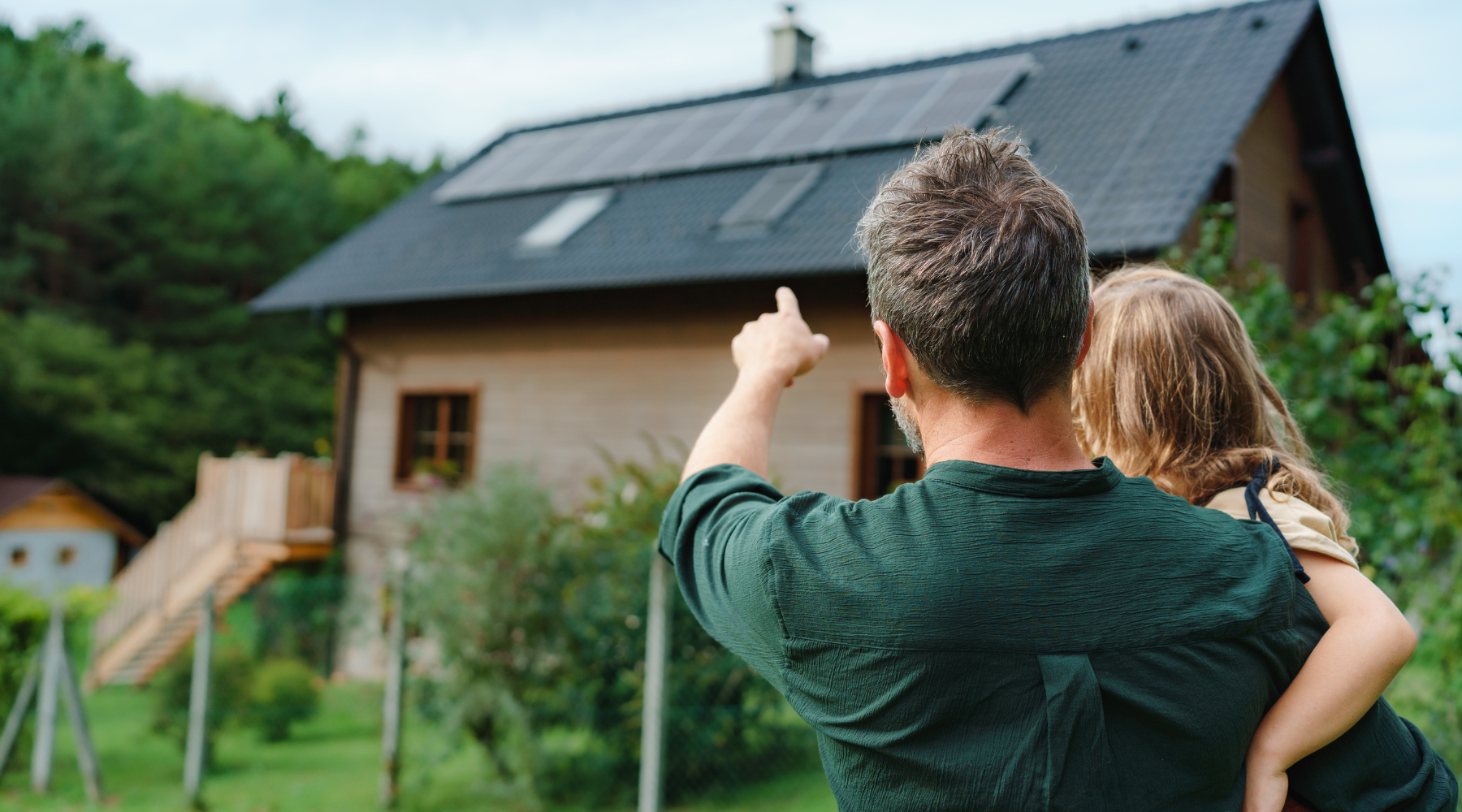 A father showing the solar & backup power system to his daughter on the roof of their house.  